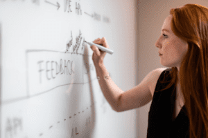 Woman writing on whiteboard