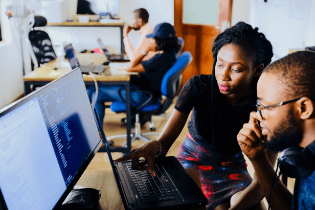 Workers looking at a computer screen